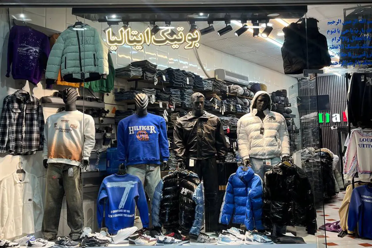 نمای بیرونی بوتیک ایتالیا، فروشگاه پوشاک مردانه شیک و مدرن با دکوراسیون جذاب، نورپردازی حرفهای و ویترین پر از لباسهای زمستانی و تابستانی با طراحی ایتالیایی